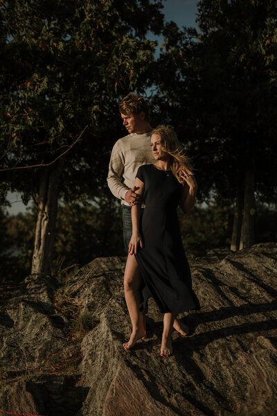 couple standing on rock at sunset