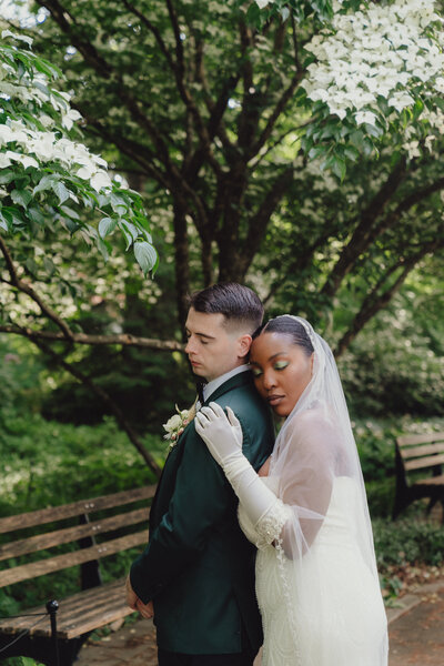bride and groom hug at the queens botanical garden