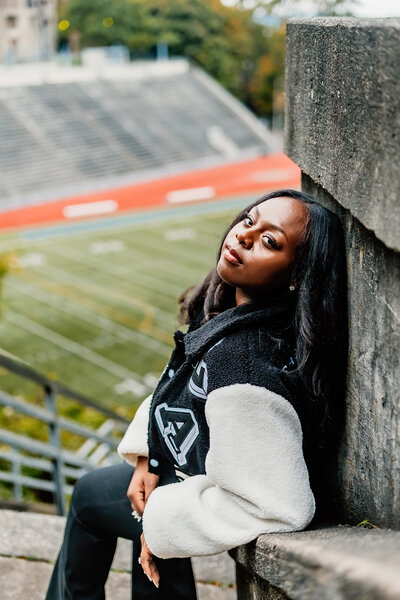 a senior girl sitting on a concrete colomn in front of stadium high school, tacoma wa