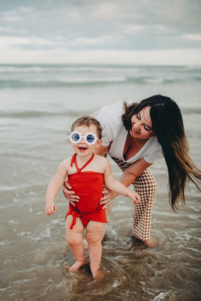 Retro vibes mom and baby daughter with floral sunglasses on the beach at South Padre Island