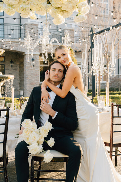 bride and groom looking at the camera hugging