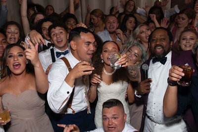 Bride, groom, and wedding guests dancing and singing along at Chicago wedding reception with Charizma DJ