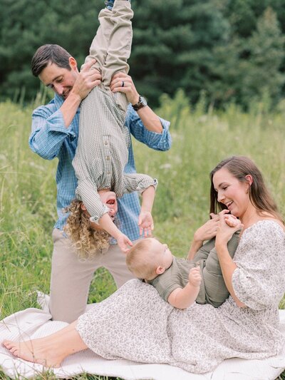 mom-and-dad-playing-with-boys-in-meadow