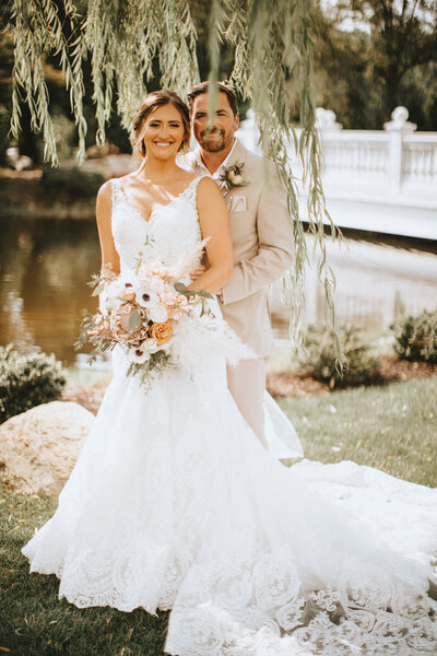 wedding couple smiling under a willow tree