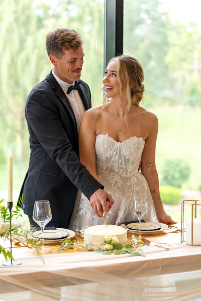 A portrait of a bride and groom cutting their wedding cake; taken by columbus wedding photographer A James Visuals.