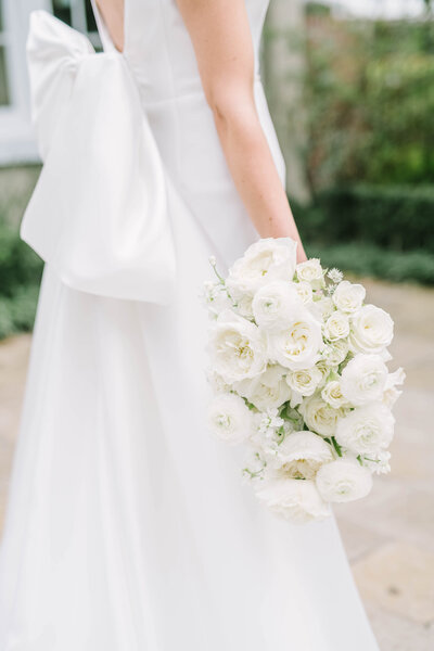 Bride holds white rose bouquet