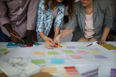 Diverse team collaborating on a project plan using colorful sticky notes.