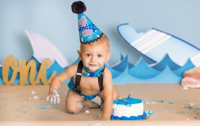 cake smash photographer, a baby crawls towards a cake with a shark background