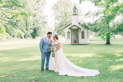 Bride and groom pose before a charming chapel. Dreamy wedding photography by Jackson Ms Wedding Photographer.