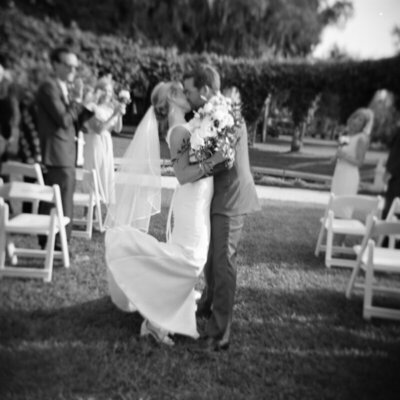 Bride and groom kissing in aisle in Florida by best film wedding photographers Noble Photo Co
