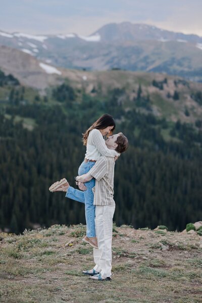 Denver Engagement Photographer, Man picks up his fiance during mountain engagement session.