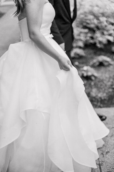 The Corteses Newport Wedding Photographer and Videographer | Serving CT, RI, and beyond | Bride and groom snuggled with each other on a deck with a white yacht behind them in Newport Rhode Island CT