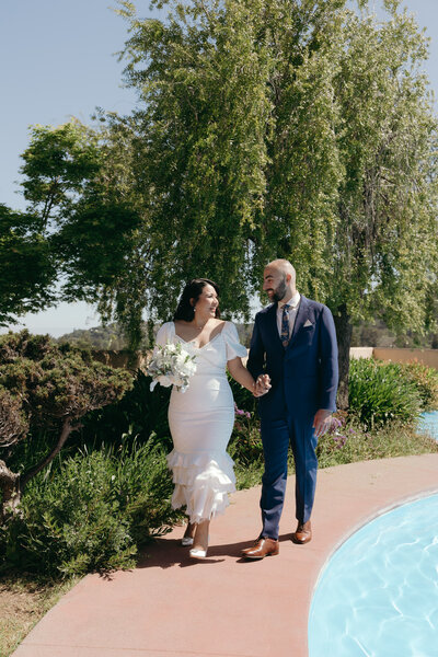 Elopement Photography, couple walking next to a pool hand in hand