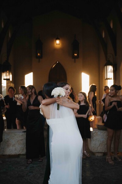 Bride hugs family member after ceremony at Chapel Dulcinea during golden hour