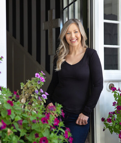 Woman standing in doorway in Christchurch to welcome her client to her home based business.