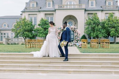 man and woman walking and looking back to a decorated arch with flowers