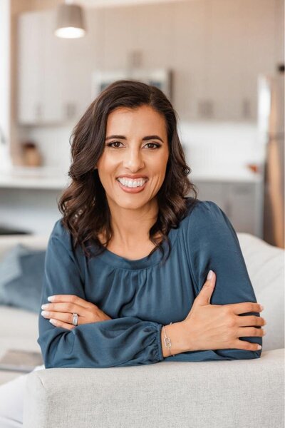 Jo, founder of Branding by Jo smiling with her arms crossed for a lifestyle headshot at a studio in Orlando.