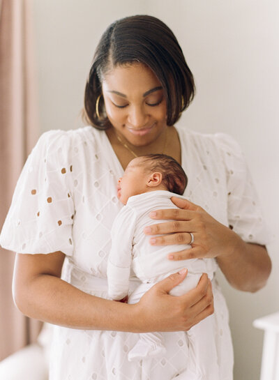 New mom cradling her son during his newborn session. Image by Raleigh newborn photographer A.J. Dunlap Photography.