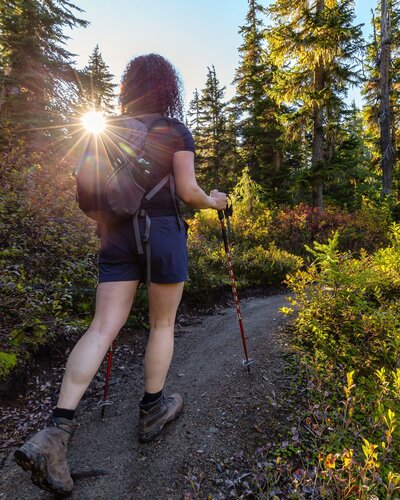 A woman hiking a trail in the sunshine