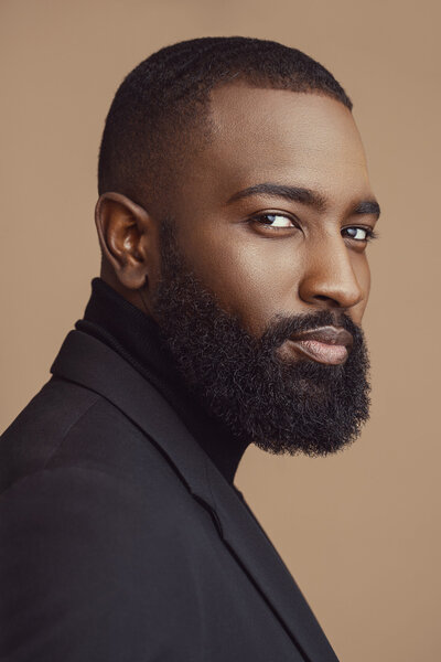 Stylish portrait of Dillard in a minimalist studio setting, featuring a sharp, confident look captured by Ylva Erevall.