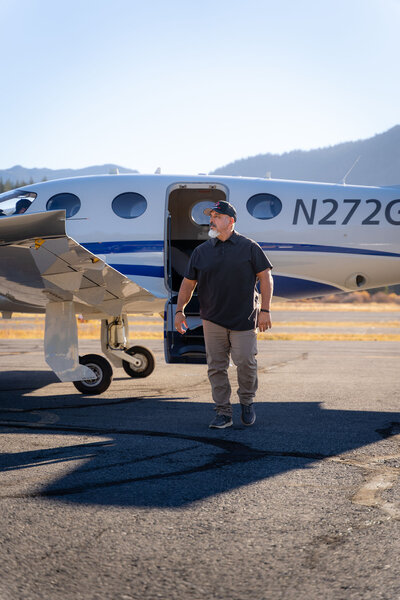 Man walking from epic e1000gx plane wearing blue