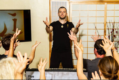 Lifestyle photo students raising hands during lecture by Jason Campbell Zen Wellness