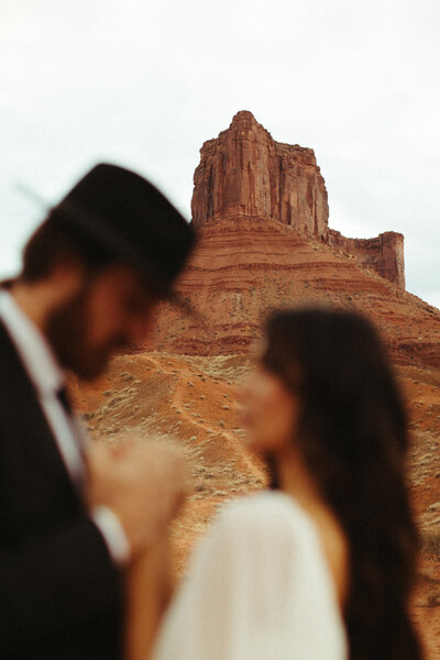 Bride holding groom's face in front of arbor