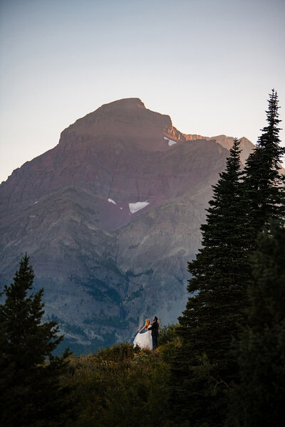 A bride and groom dance in the mountains of Glacier National Park in Montana.