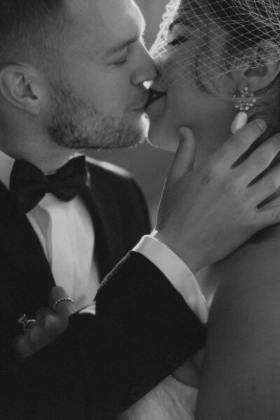 Groom holding his bride's face while kissing her on their wedding day in Washington DC, captured by Andrea-Marie Photography