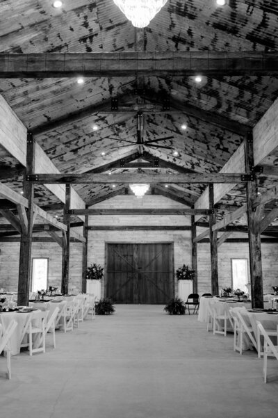 Modern western wedding setup inside The Grove with white chairs, greenery, and string lights.