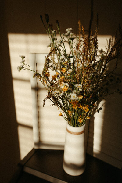 Flowers sitting on desk in sunlight in home office