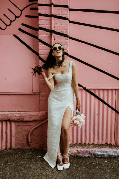 bride standing in front of pink wall in downtown Vancouver