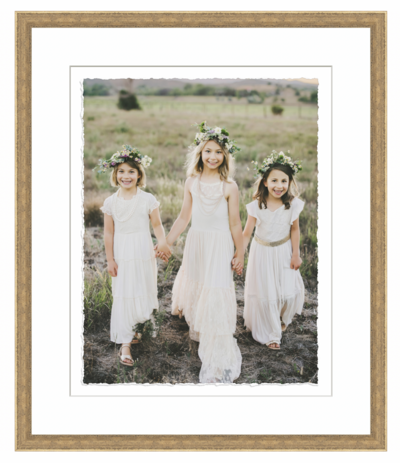 Framed portrait of three sisters holding hands wearing flower crowns in a northern colorado field.