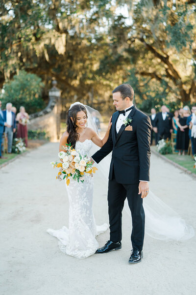 bride and groom in front of wedding guests after recessional at boone hall