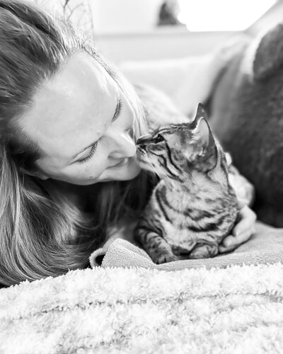 black and white image of woman kissing her cat