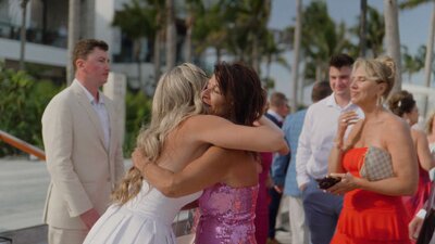 Newlyweds walking barefoot on Cancun’s white sand beach.