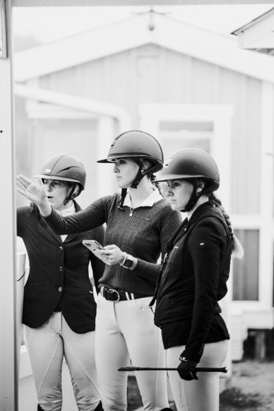 a black and white image of a group of riders studying their course walk before riding at Caledon Equestrian Park captured by a private client photographer in ontario
