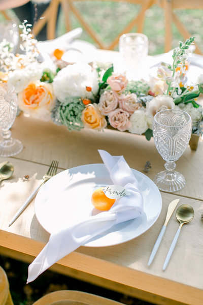 wedding reception table decorated with flowers and oranges