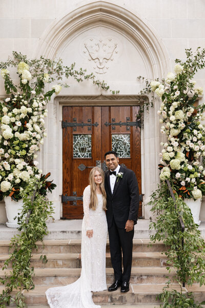 Groom gently places a soft kiss on the bride's head, captured in a tender and intimate moment.