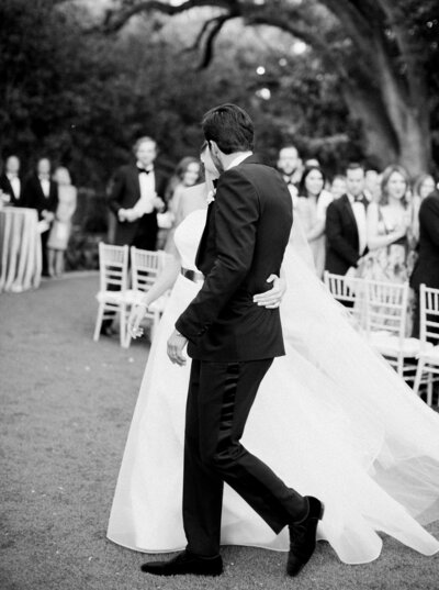 groom in tuxedo and bride in white wedding gown kissing