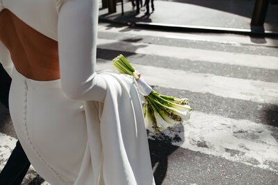 brides holding bouquet crossing street