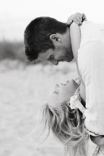 JoDad holding his daughter as her hair flows in the wind at Sullivan's island in South Carolina