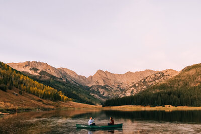 couple canoeing with mountain backdrop in colorado