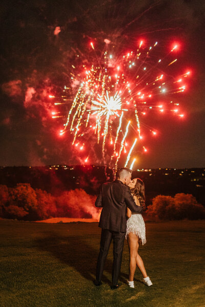 wedding couple kiss watching fireworks after reception