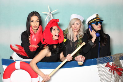 4 women dressed in sailor outfits pose nautical photobooth