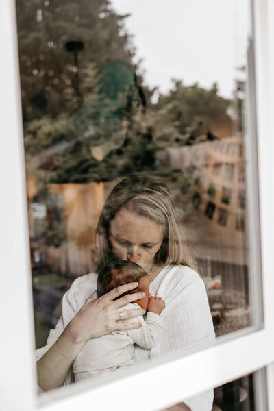 Mama kust baby achter het raam