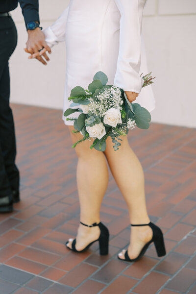 Bride’s bouquet blowing in the wind during cinematic elopement image
