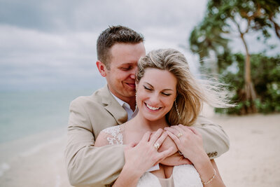 groom hugging bride from behind