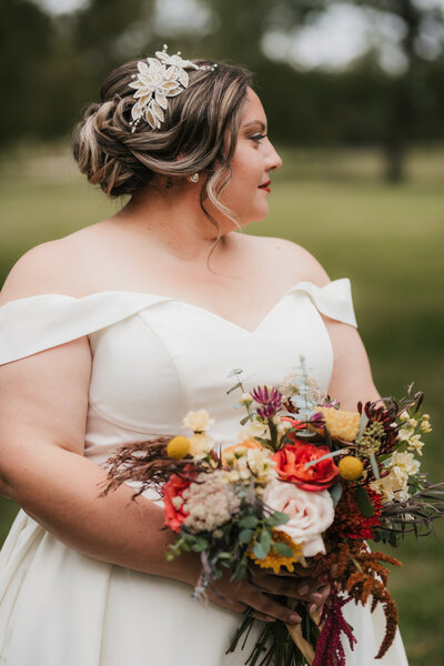 a bride holding a colorful flower bouquet
