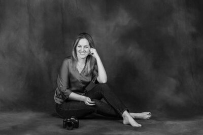 Photographer sitting in home office with a professional canon camera in her hands
